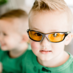 Boys in green pajamas wearing TrueDark Superhero Daylights glasses