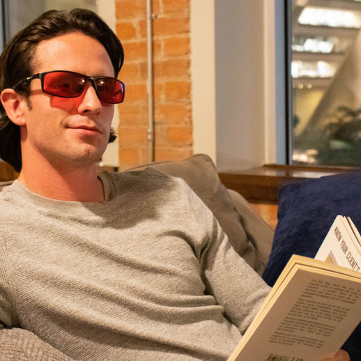 Man Wearing TrueDark Twilight Elite Glasses while reading a book