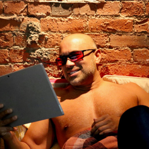 Man wearing TrueDark Twilight Elites glasses while reading on his tablet
