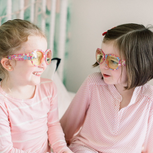 Two girls wearing TrueDark Kids Printed Daylights glasses