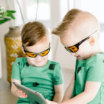 Young boys playing on tablet while wearing TrueDark Superhero Daylights