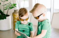 Young boys playing on tablet while wearing TrueDark Superhero Daylights
