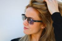 Woman playing with her hair while wearing TrueDark Daylight Transition Sunglasses
