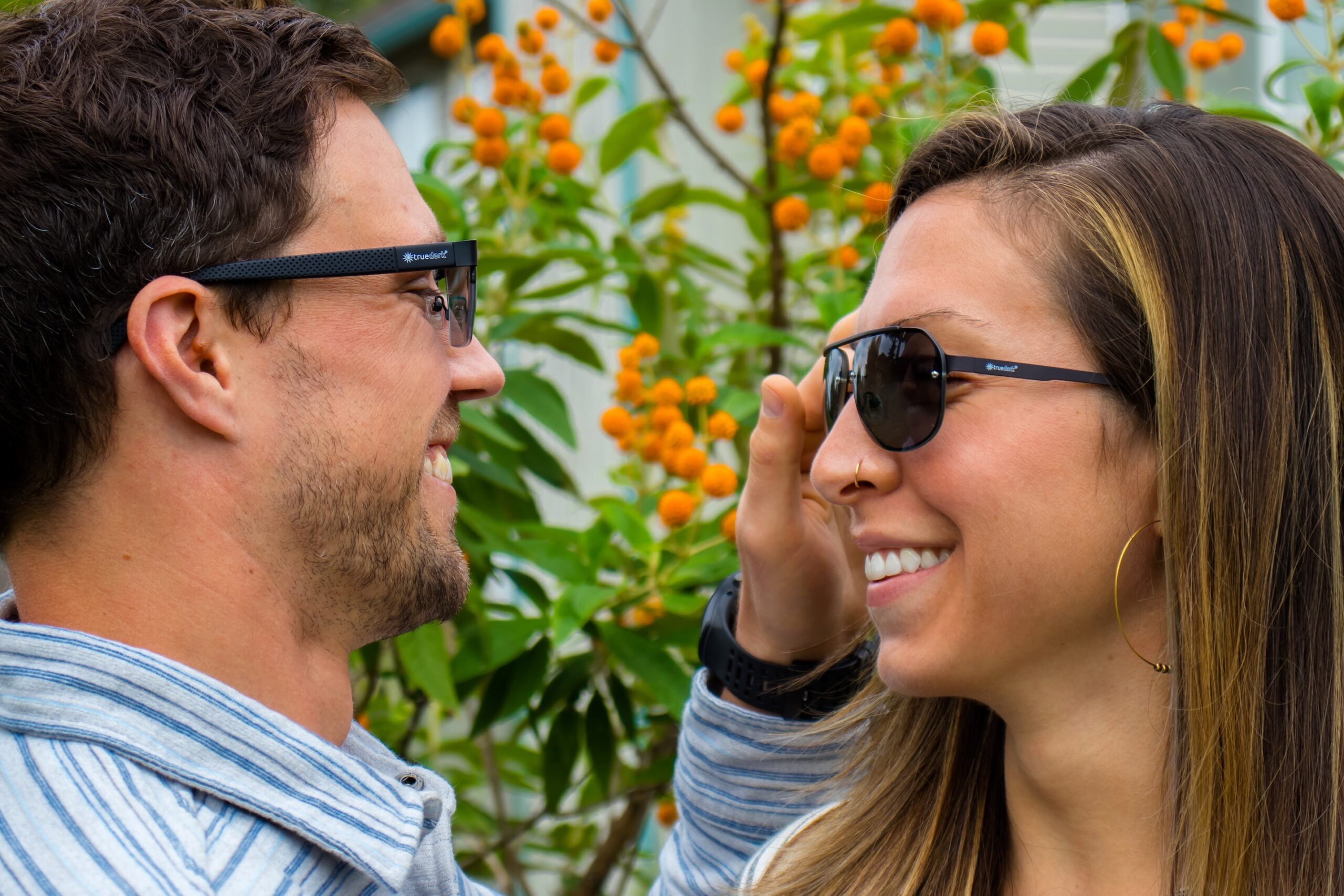 Happy couple wearing TrueDark Daylight Transition aviators and Daylight Transition Sunglasses