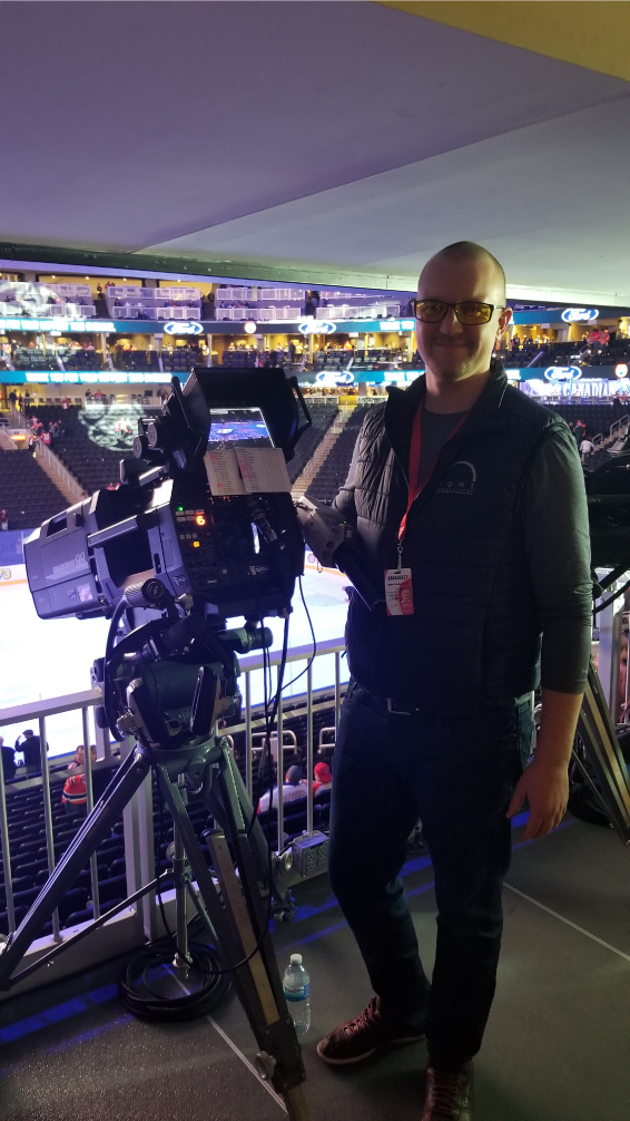 Camera man wearing Daylight Elites while airing a hockey game