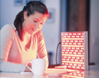 Woman writing in a notebook next to a TrueLight Energy Square