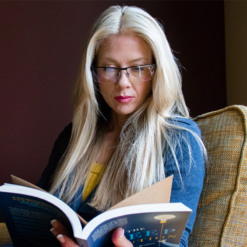 Woman reading book while wearing TrueDark Daylight Readers Glasses