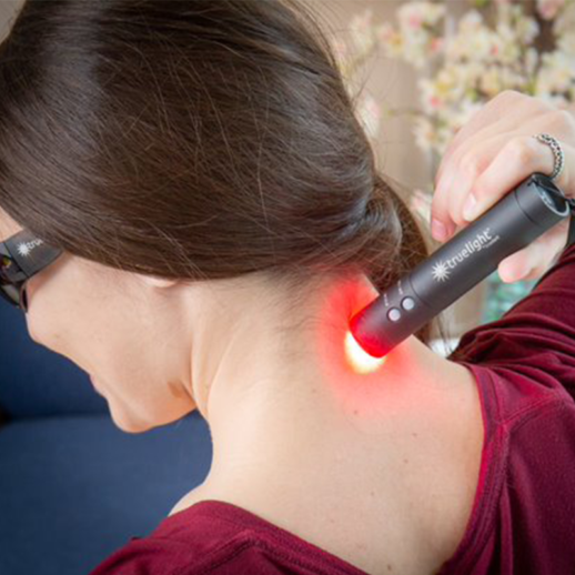 Woman Using TrueLight Baton Rouge Light Therapy focused on neck