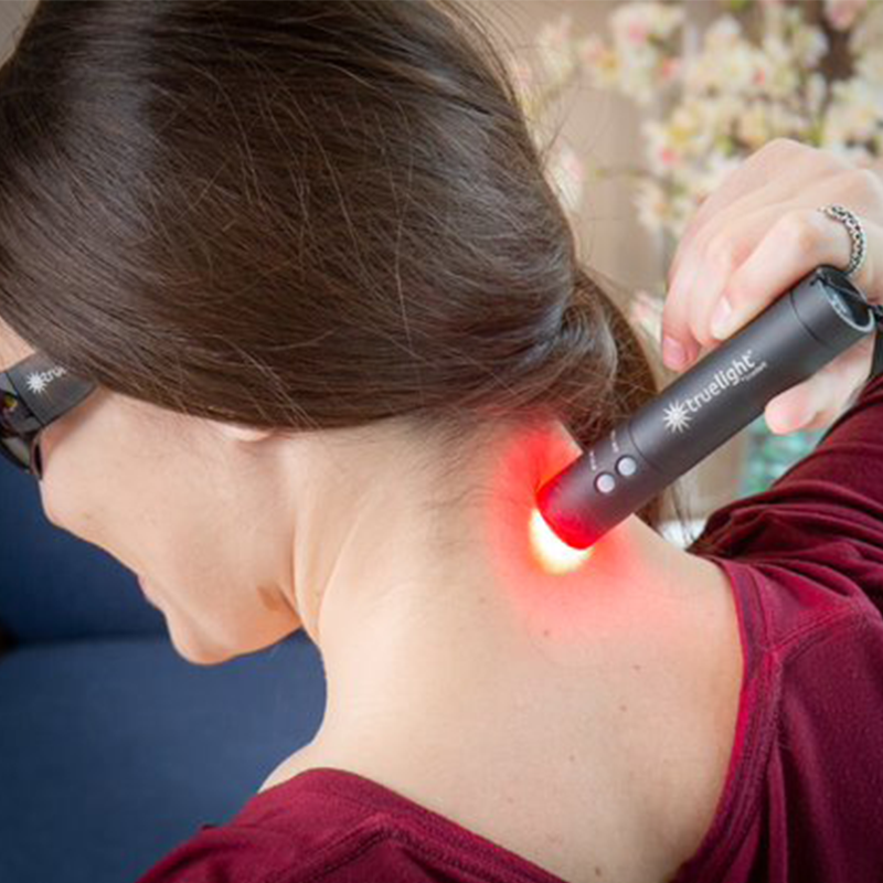 Woman Using TrueLight Baton Rouge Light Therapy focused on neck