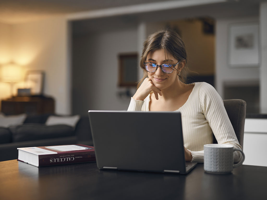 Woman in yellow top wearing tortoiseshell pro glasses on laptop