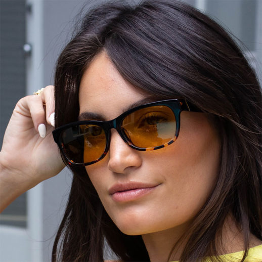 Woman wearing TrueDark Dawning Black + Dark tortoiseshell yellow transitional lens sunglasses