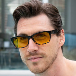 Man wearing TrueDark Dawning Black + Dark tortoiseshell yellow transitional lens sunglasses