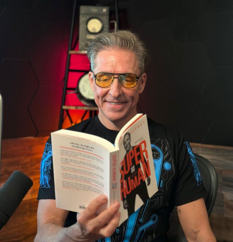 Image of Dave Asprey wearing Amber TrueDark glasses, reading a book